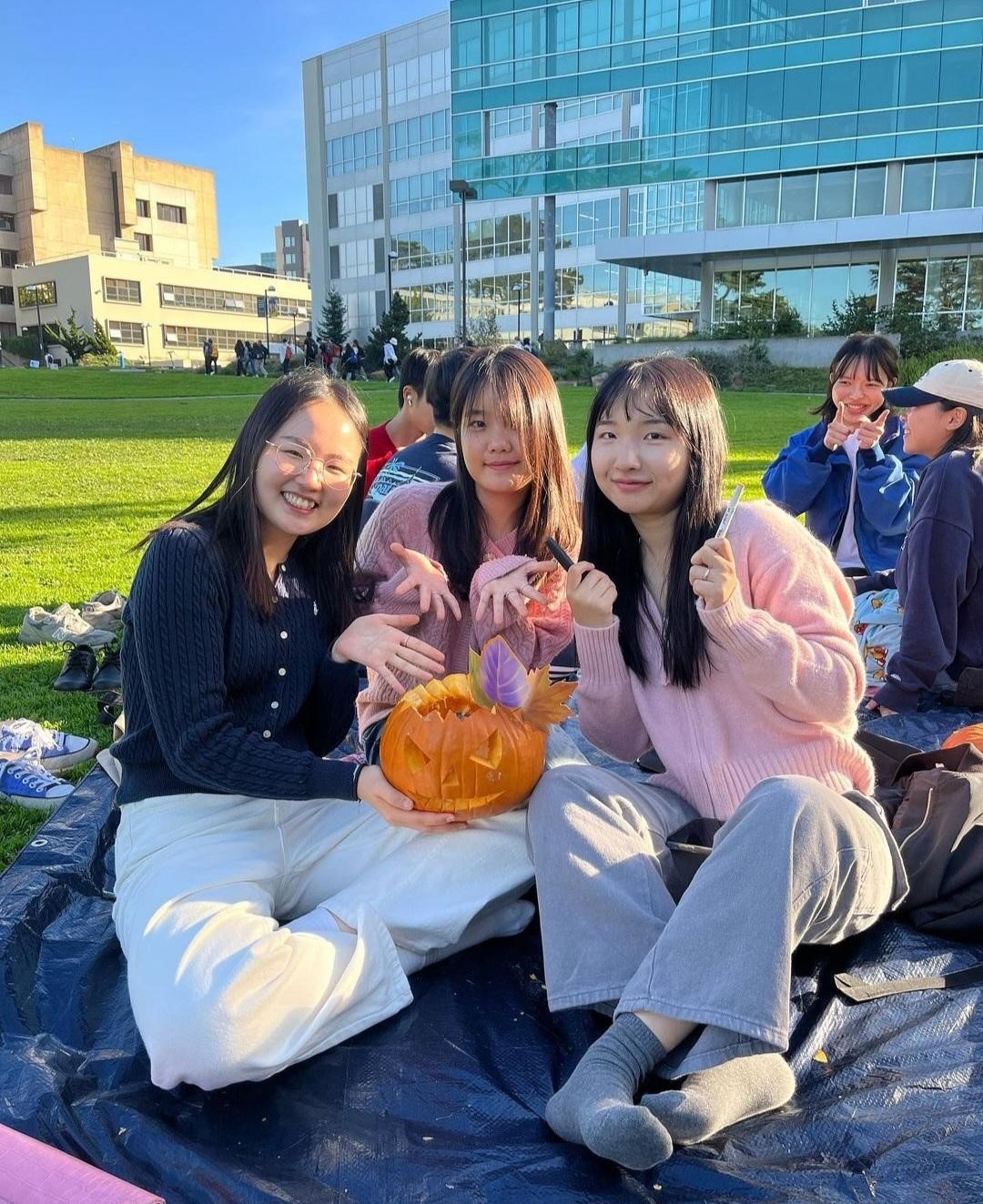 3 girls sitting with their carved pumpkin